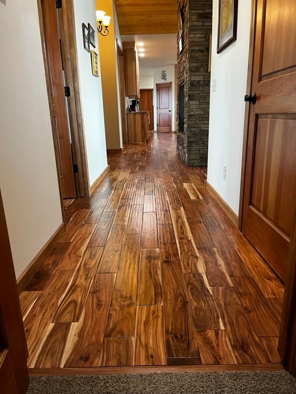 Beautiful warm hardwood floor with stone fireplace in a Wyoming home