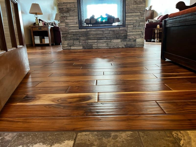A beautifully restored living room in Cody, Wyoming, with bright August sunlight streaming onto a pristine, evenly toned hardwood floor
